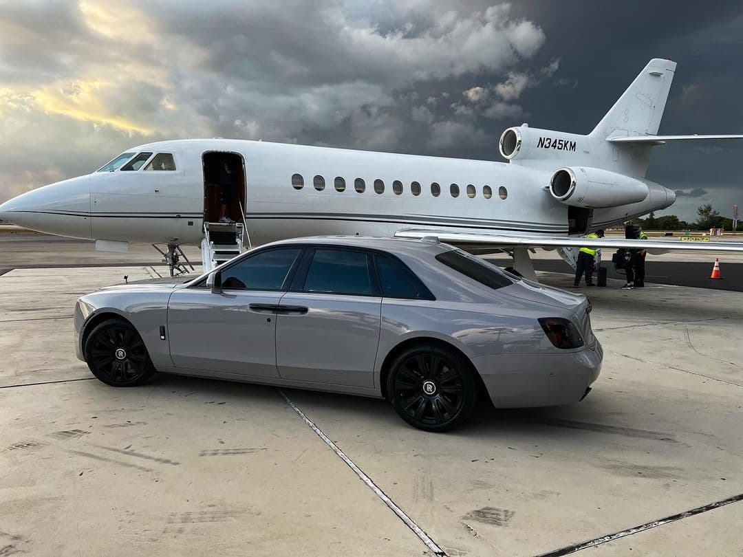 Rolls-Royce Ghost waiting beside a private jet on the tarmac